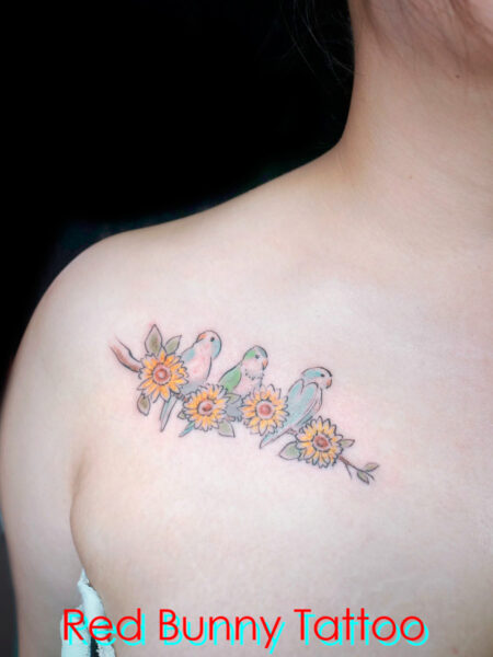 ペットのインコとヒマワリのタトゥーデザイン　女性の胸・水彩画・ワンポイントタトゥー